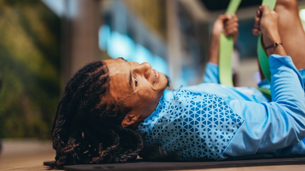 STRETCHING  : Nathan Ake uses a resistance band to stretch his legs.