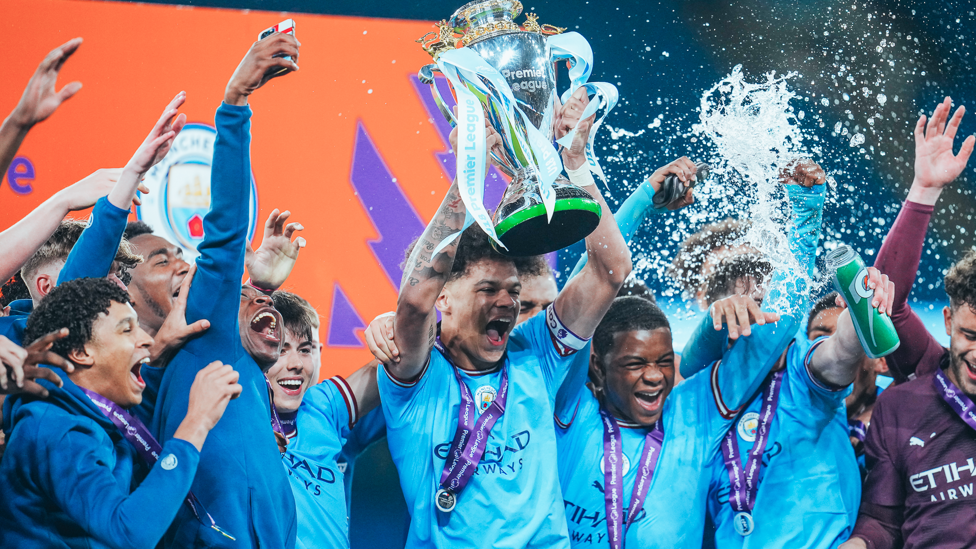 HIGH AND MIGHTY : The Premier League U18 trophy is lifted into the sky as City celebrate