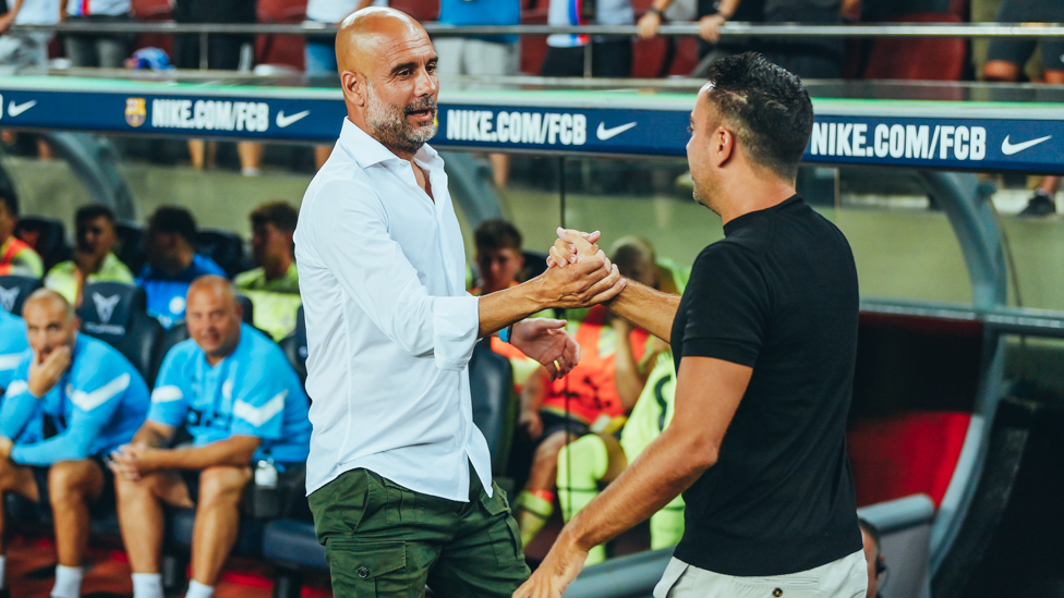 BOSSES : Guardiola and Xavi share a warm embrace ahead of kick-off.