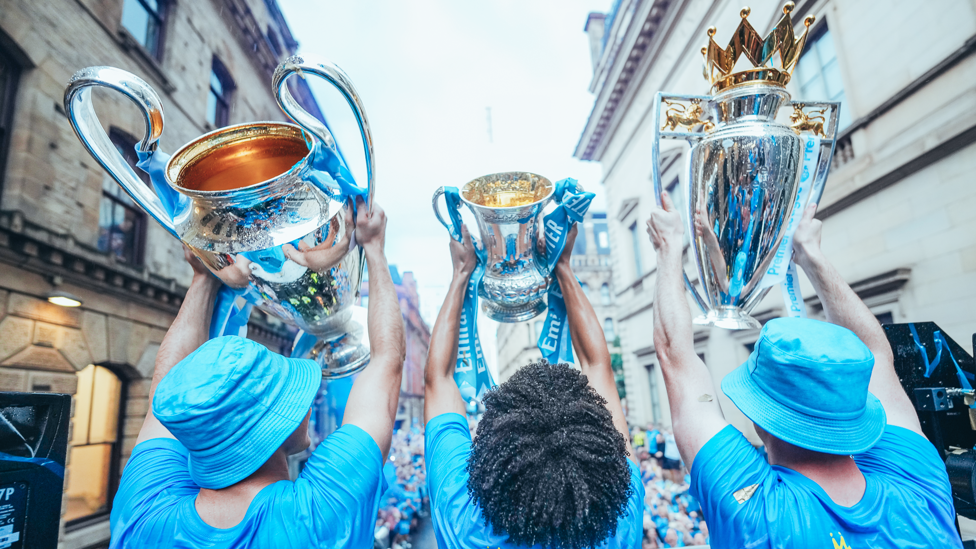 THE TREBLE  : All three senior trophies are lifted towards supporters.