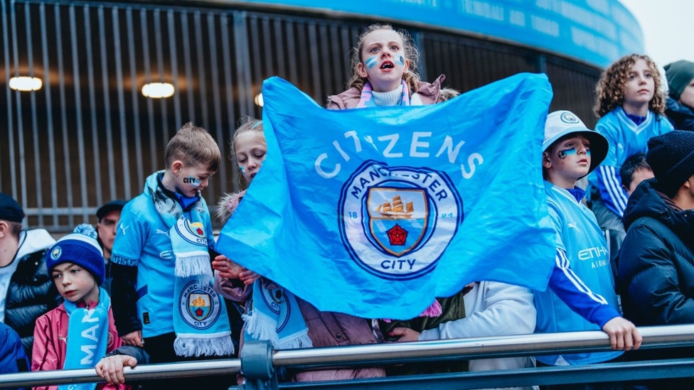 FAN FLYING THE FLAG: Young supporters getting ready to welcome the players 