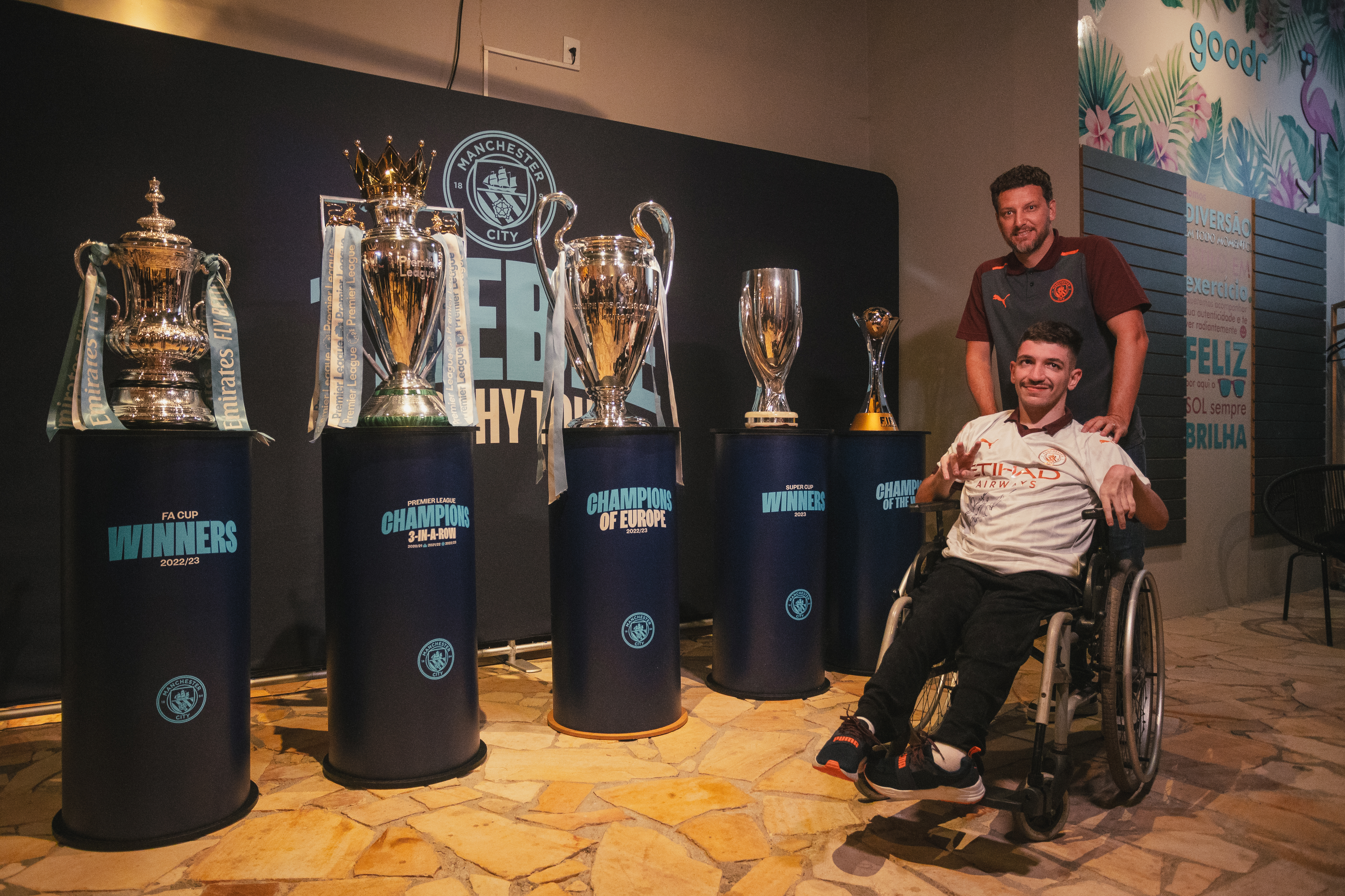 Elano showed City's silverware to Cauã. The fan was amazed by the Champions League and the Club World Cup trophy.