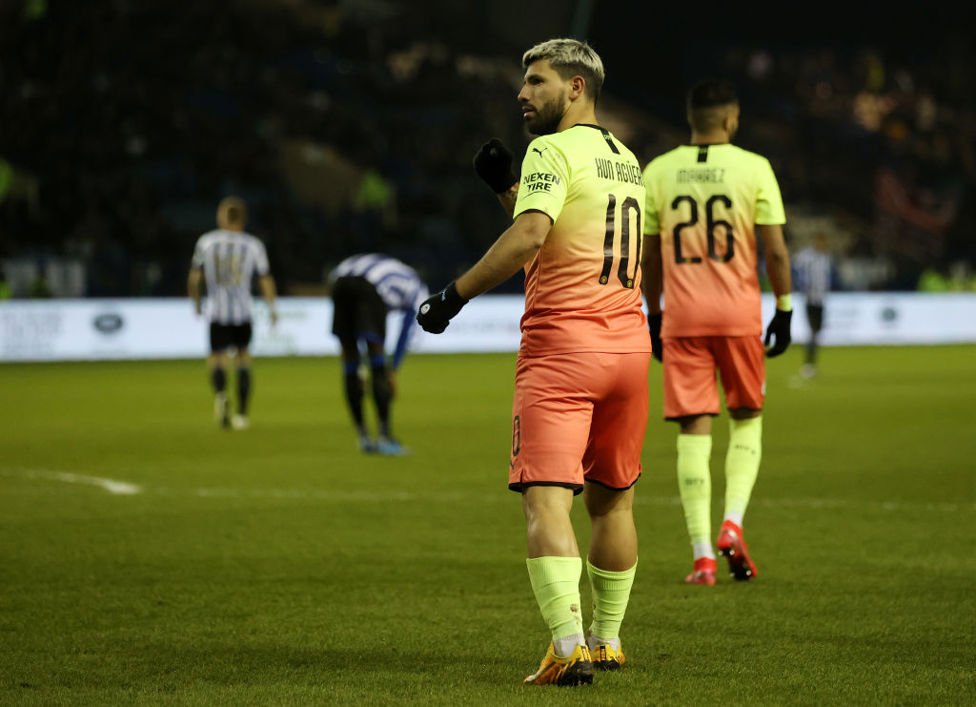 KING OF MANCHESTER: Aguero taps the badge in front of the fans!