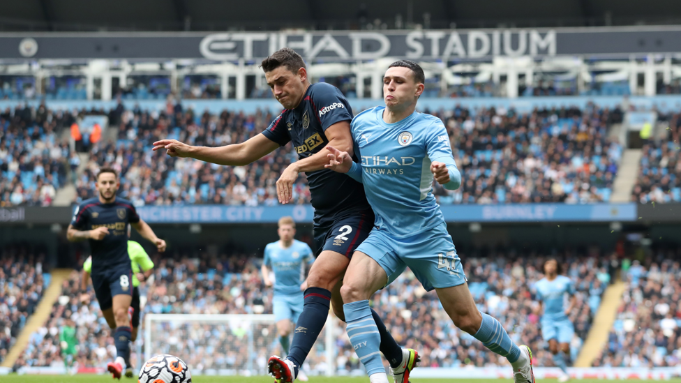 PHYSICAL  : Phil Foden and Matt Lowton battle for possession 