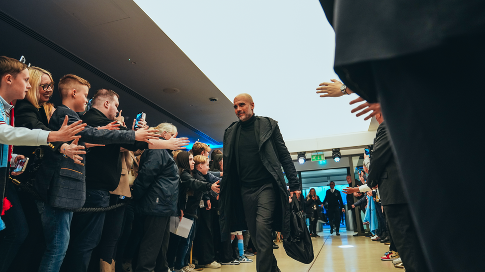 PEP: The boss is welcomed by the City fans as he leads the players in.