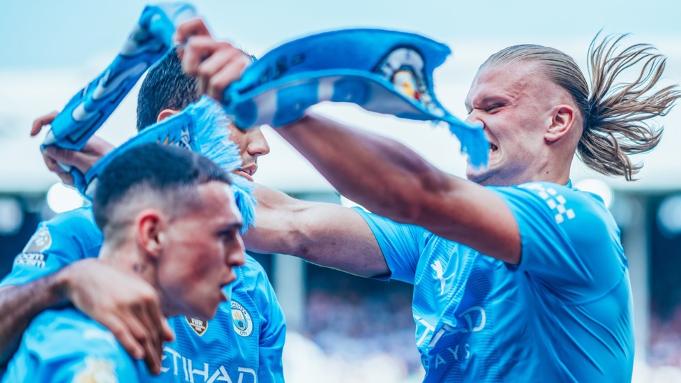 CROWNING MOMENT : Erling Haaland puts a City scarf on Player of the Year Phil Foden