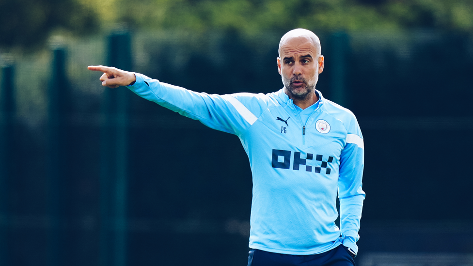 GUARDIOLA'S GUIDANCE : The manager talks his players through the session