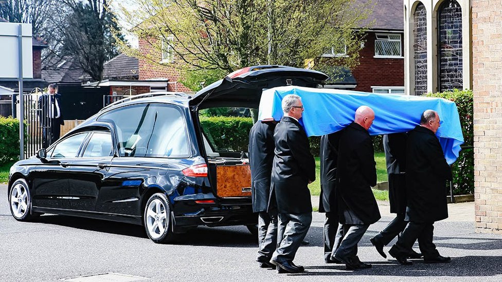 Bernard’s coffin was draped in sky blue, adorned with lilies.