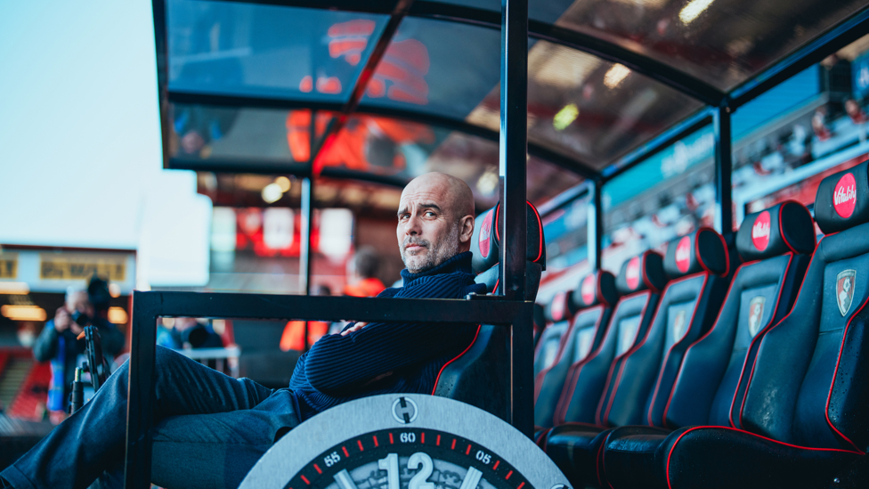 SETTLING IN : Pep Guardiola tests out his dugout seat on arrival. 