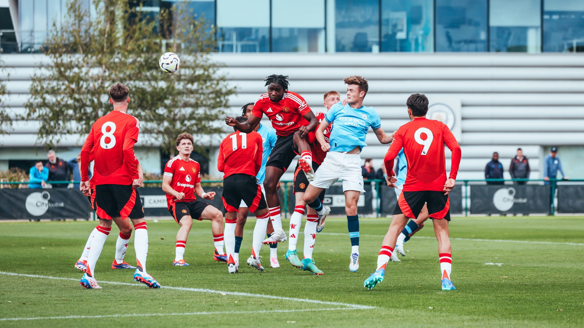 SEA OF RED : Matty Warhurst rises above the opposition to nudge the ball goal bound. 