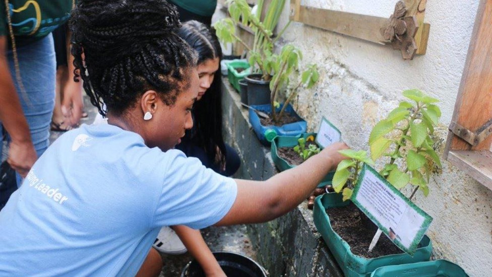 Young Leaders in São Paulo, Brazil show children the vegetable garden station at their community water festival.