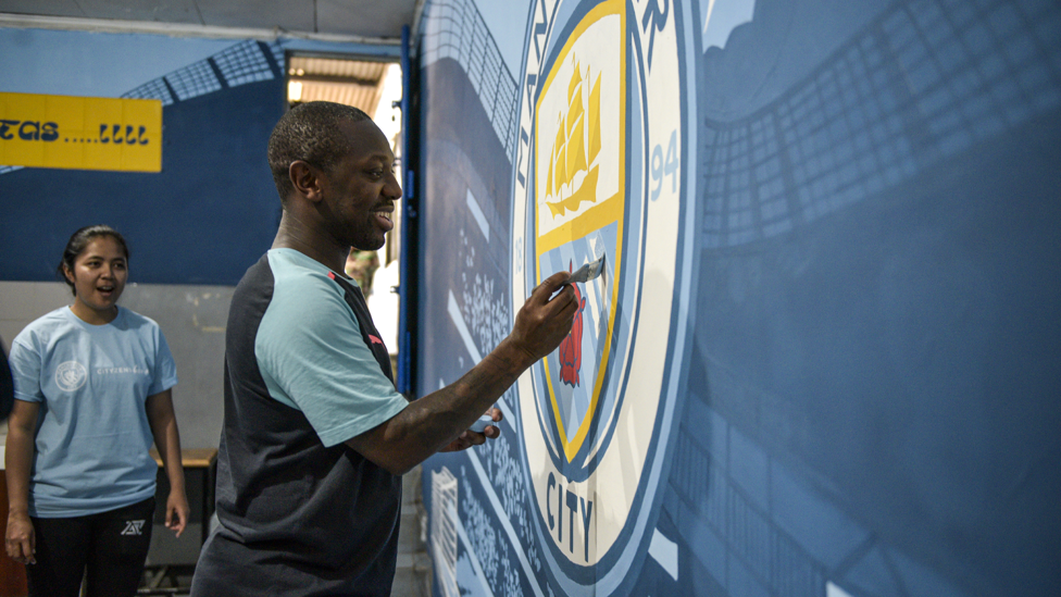 ARTIST : Shaun adds the finishing touches to a bespoke Man City mural at the project.