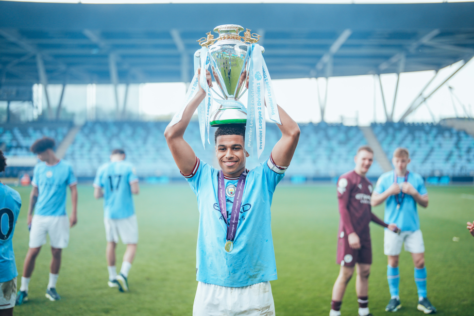 THREE FROM THREE  : EDS captain lifts the Premier League 2 title high after City won our third successive title.