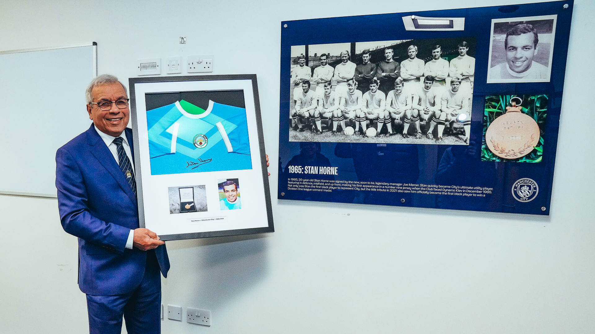 SPECIAL GESTURE: Stan proudly holds aloft the framed shirt he presented to the Club.