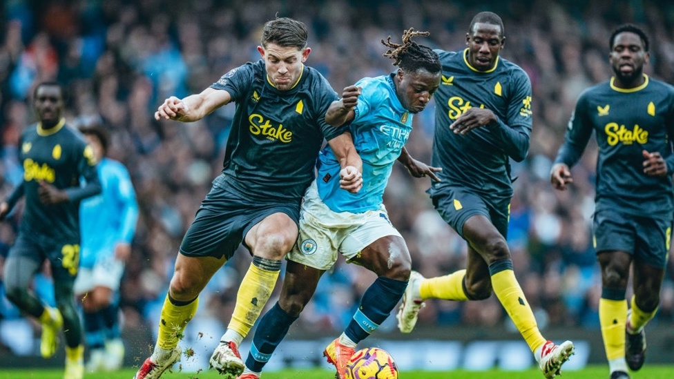 DETERMINED DOKU: Jeremy Doku bustles with Tarkowski after Everton's equaliser