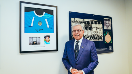 City pioneer presents framed shirt to the Stan Horne Academy classroom