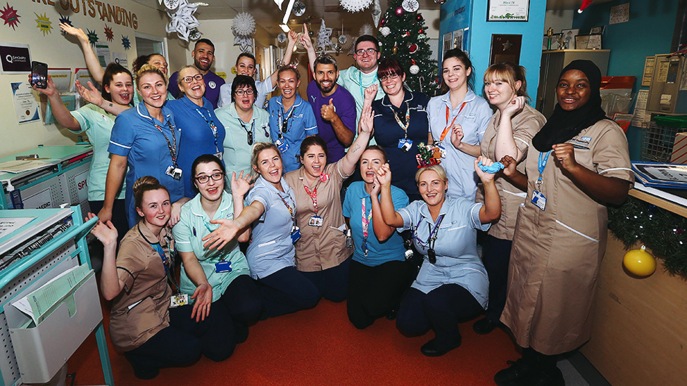 FESTIVE CHEER : Nicolas Otamendi and Sergio Aguero spend some time with staff and volunteers