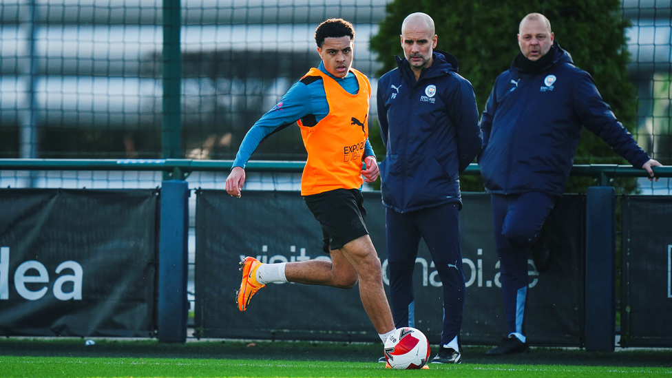 YOUNG GUN : Pep Guardiola and Rodolfo Borrell watch on as CJ Egan-Riley races forward