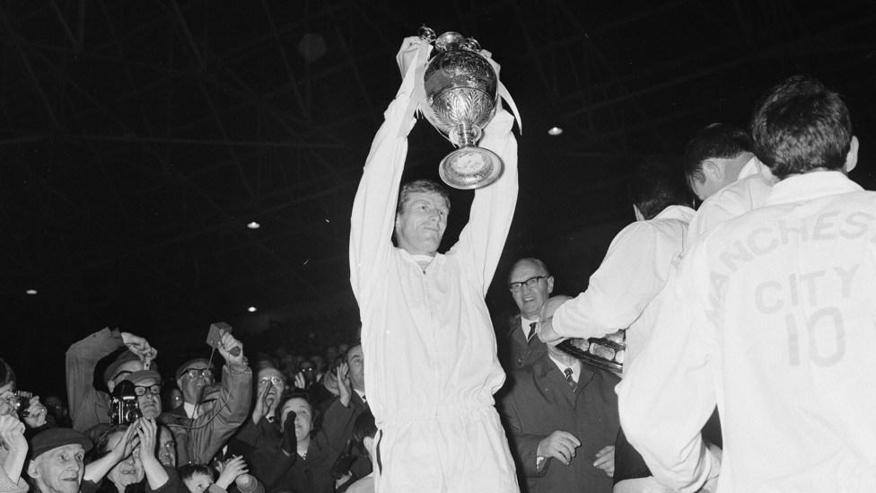 WE ARE THE CHAMPIONS : Captain Tony Book holds the League Championship trophy aloft in front of fans at Maine Road in May 1968