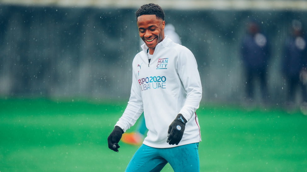 WINGING IN THE RAIN : Raheem Sterling cracks a smile despite the downpour