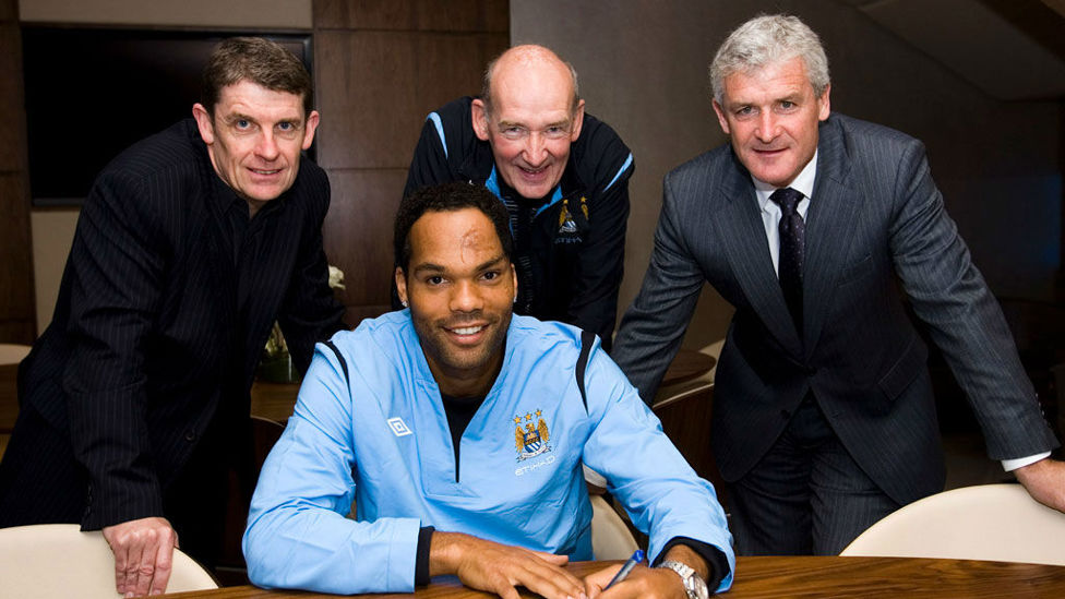 SIGN LANGUAGE : Flashback to 2009 and Bernard looks on along with Brian Marwood and former manager Mark Hughes as Joleon Lescott signs for City