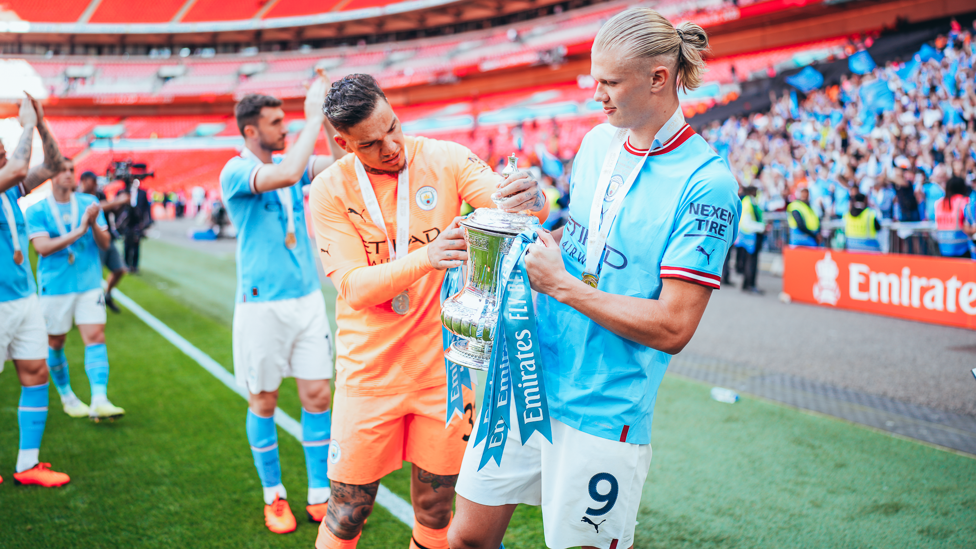 EYES ON THE PRIZE : Haaland and Ederson can't take their eyes off the trophy.