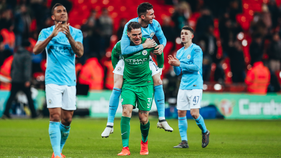 GIVE US A LIFT! : Ederson and Laporte make their way over to collect the Carabao Cup trophy after our 3-0 win over Arsenal on 25 February 2018.